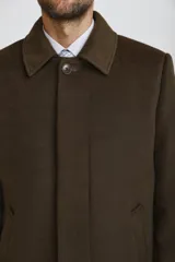 Abrigo tipo carcoat de corte clásico y estructura formal, en color azul marino. Presenta cierre frontal con botones, cuello camisero y bolsillos laterales. El interior cuenta con un forro oscuro con detalles en contraste.
