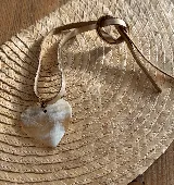 Gargantilla con dije de corazón en guampa color blanco y tiento de cuero color beige.