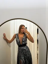 Vestido largo de seda con estampado animal print en tonos azul y plateado. Presenta un escote profundo en V con detalles en cuero sintético, doble cinturón que marca la cintura y falda amplia con dos tajos laterales.