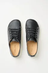 Zapatillas de cuero blanco con diseño minimalista, cordones al tono y suela de goma color suela con costura vista.