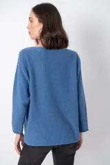 Sweater color beige claro, de corte holgado, manga larga y cuello redondo.