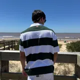 Chomba tejida de corte oversize con rayas horizontales verdes oscuras y blancas, cuello tipo polo blanco y mangas cortas.