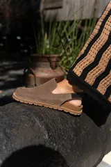 Zuecos de cuero marrón con talón descubierto y suela de goma.