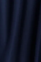 Pantalón de tejido liso color azul marino, de corte amplio y tiro alto con elástico en la cintura. Presenta una fina línea vertical blanca a lo largo de cada costura lateral exterior.