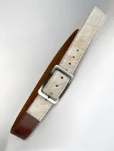 Cinturón de cuero marrón con detalle de pelo natural en tono claro en la parte frontal y hebilla metálica rectangular en color bronce.