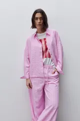 Pantalón de tiro alto con silueta amplia y caída fluida, confeccionado en tejido celeste con textura a rayas finas. Cuenta con cintura elástica con lazo de ajuste y bolsillos laterales.