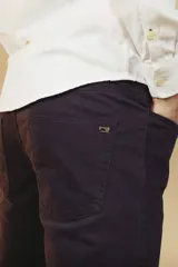 Pantalón de gabardina color beige, de corte recto y estilo clásico, con bolsillos laterales y traseros.