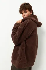 Campera tipo canguro teddy negra con capucha y cierre. El forro es de felpa color verde militar.