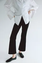 Pantalón tobillero de maternidad en punto interlock pesado color negro, de tiro alto con elástico oculto, pinzas en la parte trasera y piernas ajustadas con bajo acampanado.
