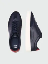 Zapatillas Boss modelo Kieran Tenn, confeccionadas en una combinación de cuero texturizado y gamuza en color azul marino. Presentan suela de goma blanca, cordones al tono y detalle de logo en color dorado en el lateral y talón en contraste.
