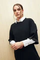 Vestido corto color rosa nude de punto, con mangas cortas y apliques de tachas plateadas en las terminaciones de las mangas.