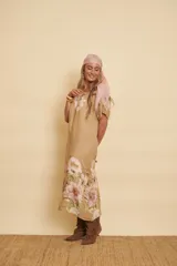 Vestido midi de lino color tostado con mangas cortas y estampado floral en tonos rosados y verdes. Presenta un diseño holgado y fresco.