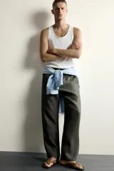 Camiseta sin mangas tipo tank top de corte slim fit, confeccionada en tejido de algodón con elasticidad, cuello redondo amplio y vivos en tejido combinado a tono.