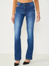 Jean de mezclilla azul oscuro con efecto lavado y sutil desgaste, de corte recto o ligeramente acampanado (bootcut).