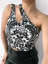 Top negro brillante de un solo hombro con abertura en el hombro izquierdo.