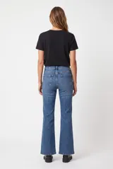 Jean flare negro de tiro alto, confeccionado en denim con bolsillos clásicos y cierre frontal de botón y cremallera.