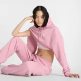 Canguro New Balance Sport Essentials de mujer, color rosa con logo bordado en blanco.