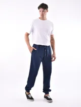 Pantalón deportivo negro, tipo jogging, con cordón ajustable en la cintura y puños elásticos en los tobillos.