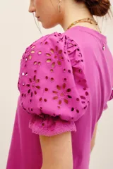 Remera fucsia con mangas abullonadas de broderie estilo globo, con cuello redondo y diseño liso en el cuerpo.