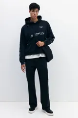 Pantalón cargo de sarga de algodón con corte relajado, cierre de botón y cremallera, bolsillos laterales tipo cargo con solapa y botones a presión ocultos.