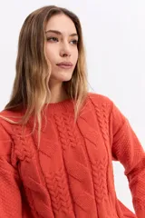 Buzo de punto color blanco, con cuello redondo y diseño de trama combinada con detalles trenzados. Presenta terminaciones tejidas en puños y ruedo.