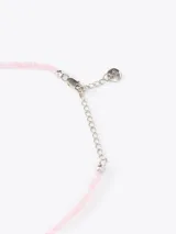 Collar de mostacillas de vidrio rosadas con dijes metálicos en forma de corazón y cadena de extensión de acero inoxidable.