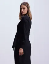 Vestido negro midi cruzado con estampado floral, escote en V y lazo de ajuste en la cintura.