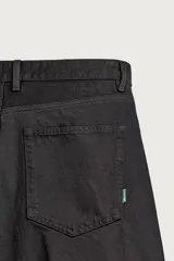 Pantalón barrel fit de mezclilla color verde militar, con efecto lavado, cinco bolsillos, cierre frontal con cremallera y botón, y detalle de pinzas en las rodillas.