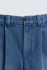 Bermuda de denim de algodón con corte relaxed fit, cintura con pliegues dobles en el delantero, bolsillos laterales y traseros de doble vivo, con efecto lavado y cierre frontal con cremallera y botón.