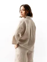 Camisa unisex de lino con mangas tres cuartos, cuello clásico, cierre frontal con botones y un bolsillo aplicado en el pecho.