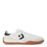 Championes Converse Run Star Trainer OX, de diseño urbano con capellada de tela y refuerzos de gamuza en tono crema. Presenta el logo de estrella y chevron en color negro en el lateral, con suela de goma color caramelo y detalle en el talón.