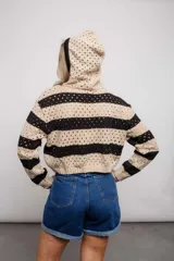 Buzo de tejido de punto calado color beige con rayas horizontales rojas y capucha.