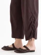 Pantalon de tiro medio color beige, confeccionado en twill, con fit relajado, pierna ancha estilo babucha, bolsillos laterales y traseros tipo ojal, y presillas en la cintura.