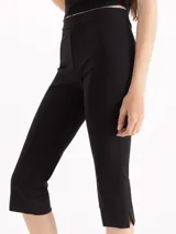 Pantalón tipo pescador negro de tiro alto, confeccionado en tejido de punto suave, con recortes en el centro delantero y tajos laterales en el ruedo.