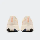 Championes de running New Balance Fresh Foam X 1080 V14, color crema/beige claro, con logo 'N' en gris oscuro y detalles en naranja en la suela. Presentan una entresuela gruesa con tecnología Fresh Foam X y suela de goma.