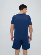Remera deportiva Umbro modelo Axis, de manga corta, color gris claro con textura perforada transpirable y logo negro de la marca en el pecho.