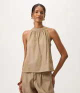 Blusa halter sin mangas confeccionada en mezcla de algodón, viscosa y lino, con cuello redondo fruncido y diseño fluido.