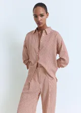Pantalon de tiro medio con diseño recto y largo, confeccionado en tela con estampado de rayas verticales. Cuenta con detalle de pinzas en la parte frontal, bolsillos laterales y bolsillos de ribete en la parte posterior. Incluye trabillas para cinturón y cierre oculto con botón, gancho y cremallera.