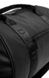 Bolso deportivo tipo duffel color negro, confeccionado en tela tracker impermeable de alta resistencia. Cuenta con compartimento lateral independiente para calzado o ropa húmeda, manijas de mano reforzadas y correa regulable extraíble. Incluye bolsillo frontal con cierre y detalles de cintas con logo grabado.