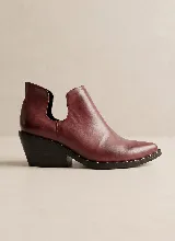 Botín de cuero vacuno color negro, con diseño de corte lateral y taco cuadrado de 5 cm. Presenta punta fina y suela de caucho antideslizante.