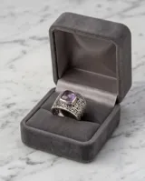 Anillo de plata 925 con diseño de filigrana y piedra amatista central de corte rectangular.