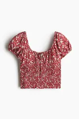Blusa de viscosa con estampado floral, escote redondo con cordón ajustable, mangas cortas abullonadas con elástico y cuerpo fruncido tipo nido de abeja.