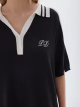 Vestido midi tejido color rojo, con cuello camisero azul marino y rayas blancas, escote en V con tres botones, manga corta con detalle de raya azul marino y aberturas laterales en el ruedo.