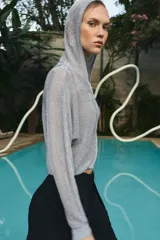Sudadera de punto con hilo metalizado color gris, con capucha, manga larga y cierre frontal con cremallera.