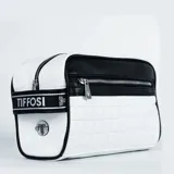 Necessaire Tiffosi color blanco con detalles en negro, diseño acolchado tipo cuadrillé en los laterales y logo metálico en el frente. Cuenta con cierre principal y bolsillo frontal con cierre. Incluye una correa lateral con el nombre de la marca.