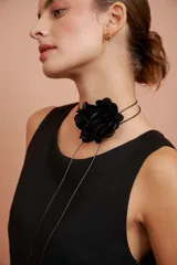 Choker negro con diseño de flor en relieve y tiras finas colgantes.