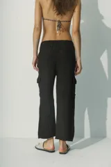 Pantalón de lino blanco, de corte recto y tiro alto, con bolsillos laterales y traseros.