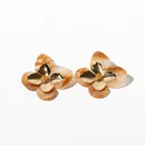 Aros colgantes con forma de flor, con pétalos color crema marmolado y centro dorado.