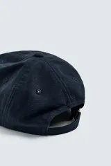 Gorra de seis paneles color azul marino, confeccionada en tejido de algodón con efecto ligeramente lavado y visera curva. Presenta ajuste posterior.