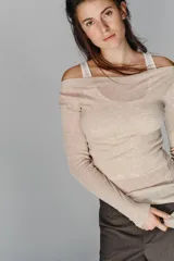 Camiseta de manga larga con diseño asimétrico y efecto de doble capa. Presenta un cuello redondo y un detalle de fruncido lateral que aporta textura a la prenda.